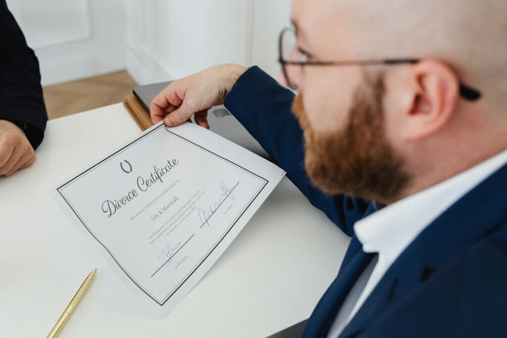 A man holding a divorce certificate in a formal office environment.