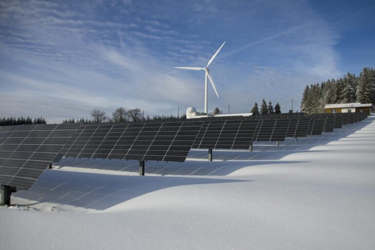 Solar panels and wind turbine in a snowy landscape, showcasing renewable energy sources. pembangkit listrik tenaga surya. solar energy.