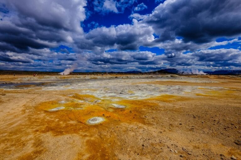 Vivid geothermal landscape with steam vents under a dramatic cloudy sky. geothermal